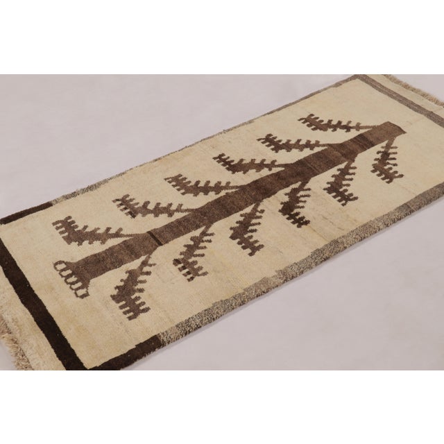 Hand-knotted in wool circa 1950-1960, this 3x6 vintage Persian Gabbeh runner is a soulful entry in Rug & Kilim’s curation...