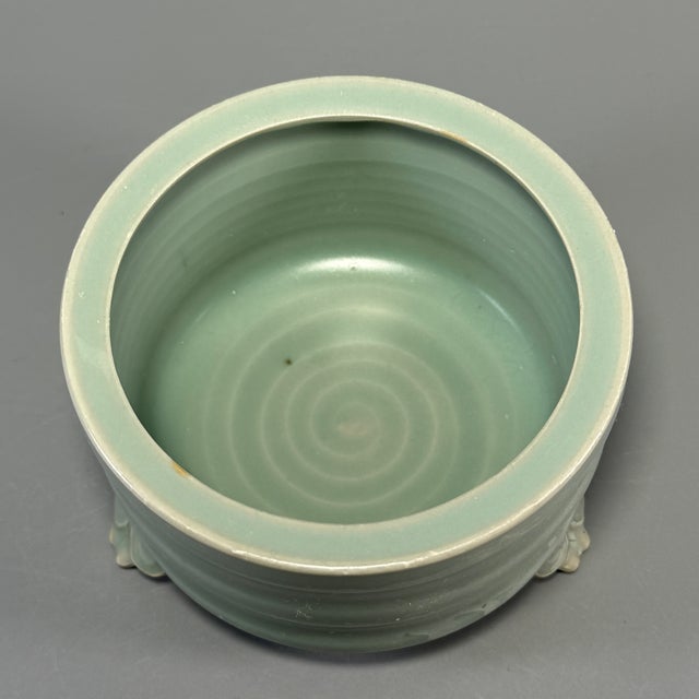 This vintage Chinese Longquan celadon tripod censer stands on three sculpted feet. Tiered horizontal‑ring decoration runs...