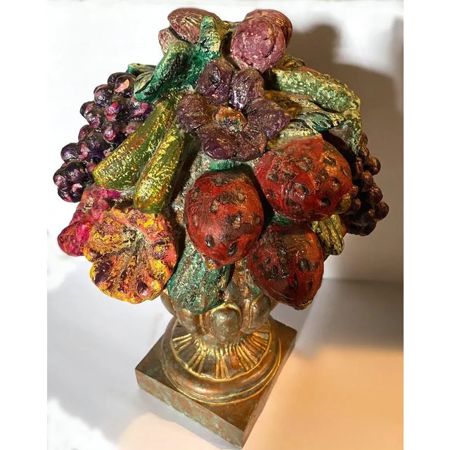 Vintage cast composite urn filled with fruit.