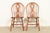 A gorgeous pair of American Colonial style solid oak spindle back Windsor side chairs or dining chairs In the manner of...
