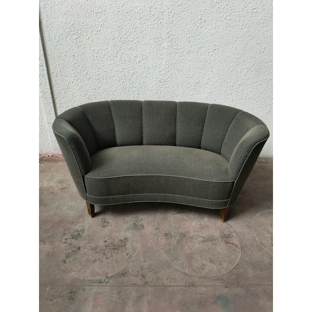 : Two-seater sofa with a curved and elegant design. – Fabric upholstery. – Wooden frame. – Wooden legs. Dimensions: Length...