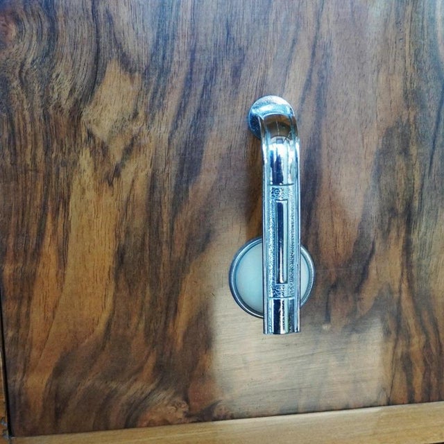 An Art Deco Chest of Drawers. Burr walnut and figured walnut veneered with original metal and bakelite handles....