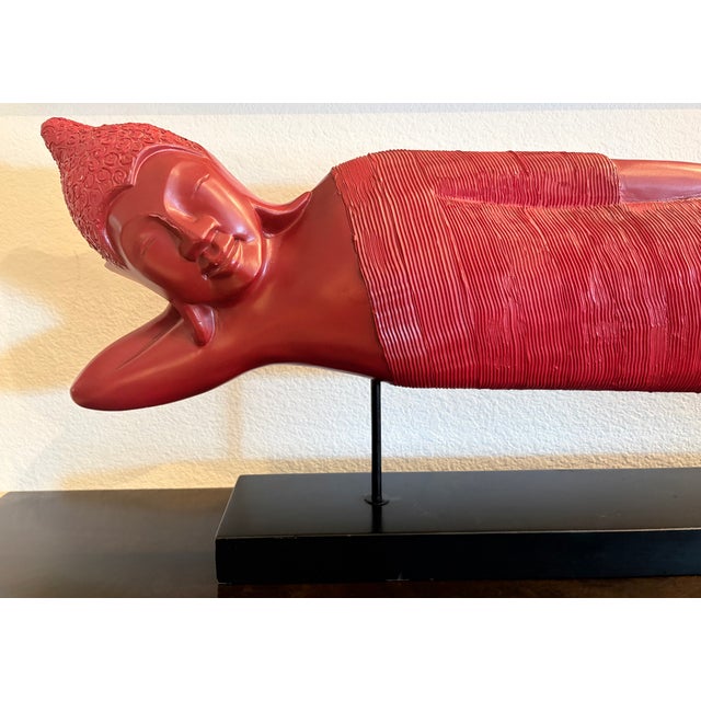 Red reclining Buddhas symbolize the historical Buddha's final moments of earthly life as he enters Parinirvana—the state...