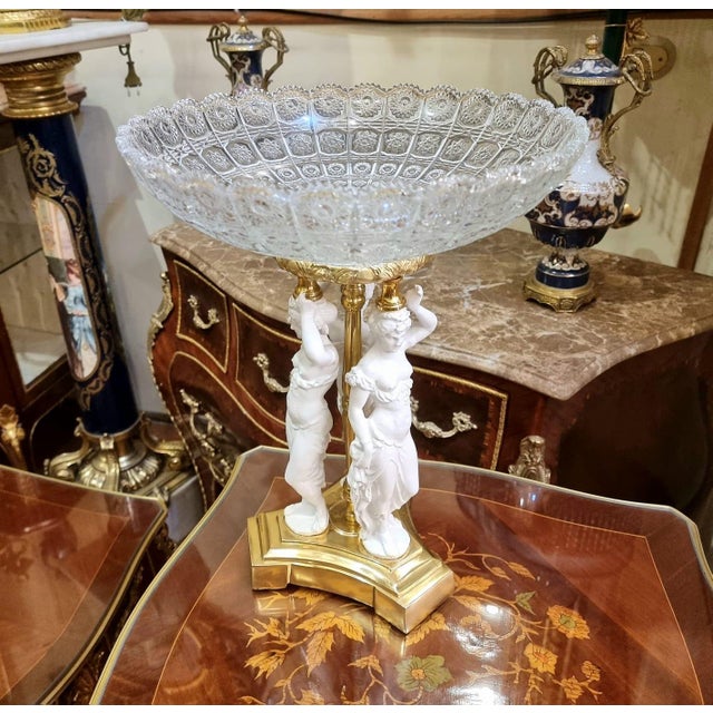 Elegant French classical style centerpiece bowl featuring an intricately cut crystal glass basin supported by sculptural...