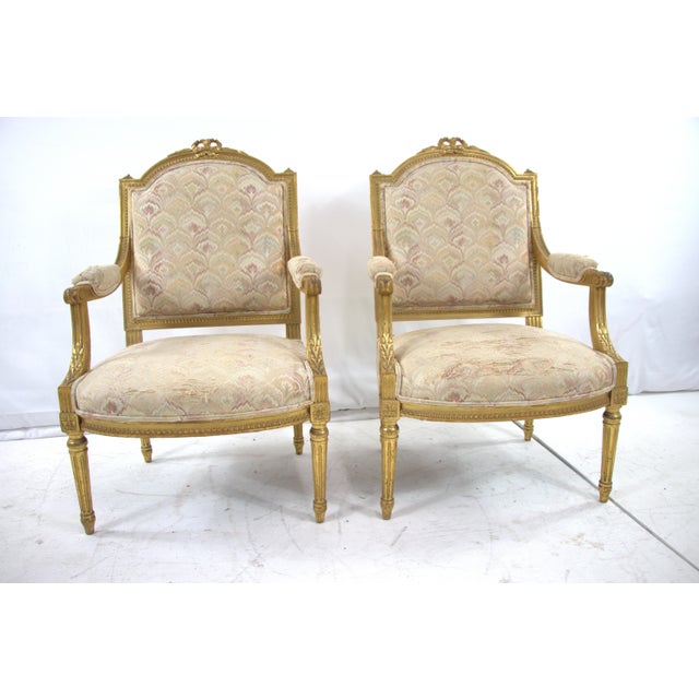 Pair of Antique Louis XVI Arm Chairs, wooden frame that shows detail wood carving all around the chair. Wooden frame is in...