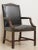 Manufactured by Kindel Grand Rapids distressed armchair with worn black tortoise leather upholstery and wooden frame....