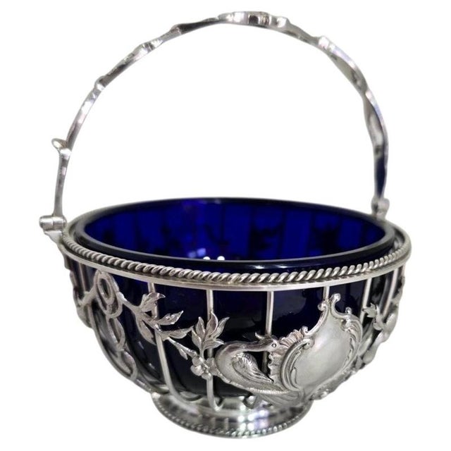 A fine george v sterling silver swing-handle bon bon or sucrier basket dating to 1912, displaying an elegant combination...