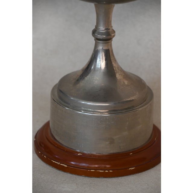 A proper two-handled silver cup on a turned wooden base engraved with a winners' inscription and carrying the unpolished...