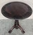 A beautiful finely carved British Colonial wooden circular side table from India or Ceylon. The circular top with a broad...