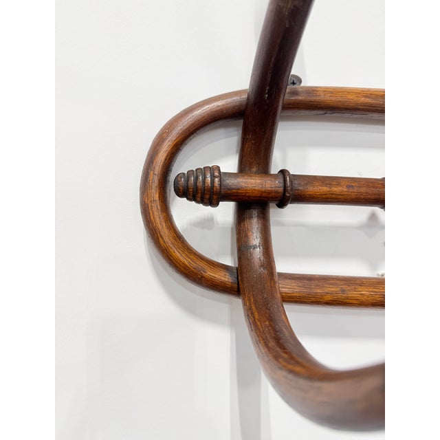 Formed in steam-bent hardwood in the tradition of Thonet and the Central European bentwood workshops, this elongated wall-...
