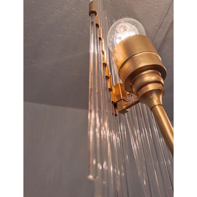 A rare and elegant 1970s chandelier, featuring five E27 sockets, clear glass rods, and beautifully renewed brass-coated...