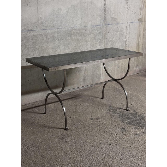 Modernist console table in brushed steel and smoked glass - 1970s in the style of Maria Pergay. This console table...
