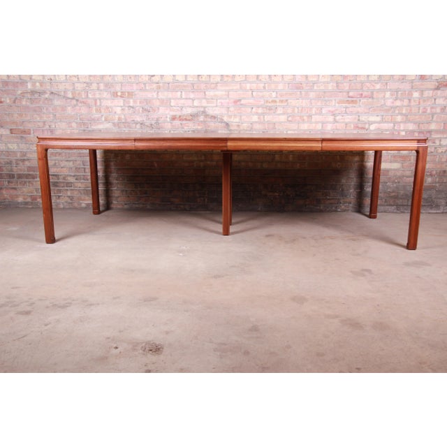 An exceptional mid-century modern extension dining table in book-matched walnut By Edward Wormley for Dunbar Furniture...