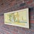 Mid-century modern cityscape by Robert C. Brisley. The painting depicts a building with a sculpture, light fixture, and...