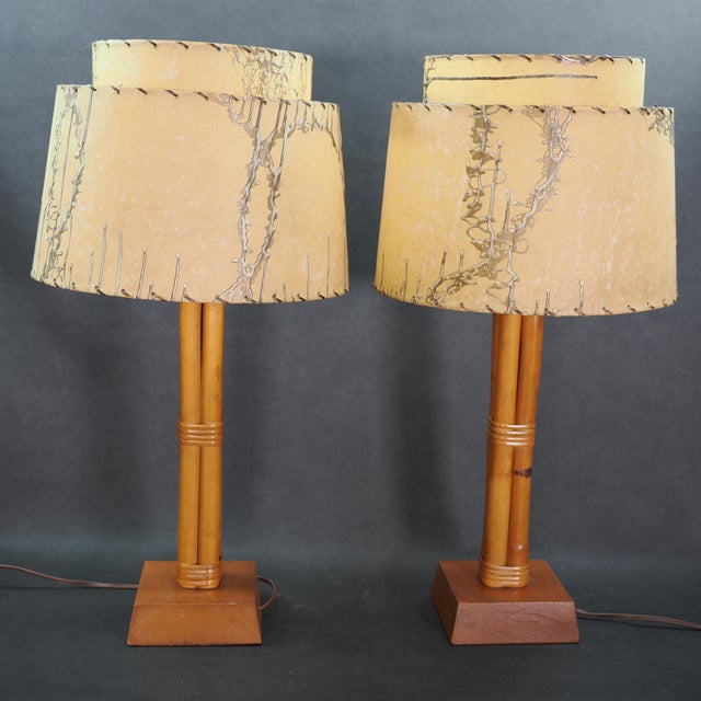 A staple of Tiki or Hollywood Regency styles, this vintage pair of lamps feature bamboo rattan bodies with square bases...