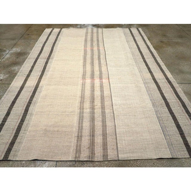 This mid-20th century Turkish Flatweave Kilim rug, embodies a refined minimalist aesthetic with its delicate interplay of...