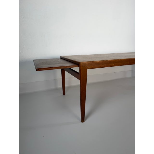 Classic Danish coffee table dating from the 1950s/60s, finished in teak veneer. Its minimalist form, slender tapered legs...