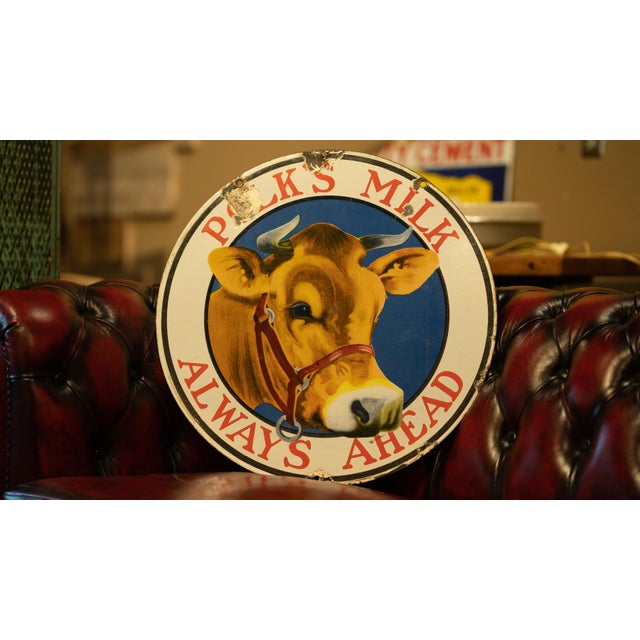 Circular double-sided porcelain advertising sign for the Polk Sanitary Milk Company of Indianapolis, Indiana. The colorful...