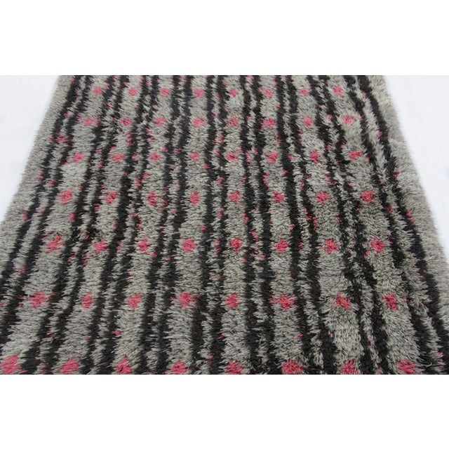 Hand-knotted in lush, high-pile wool in Sweden circa 1960-1970, this 4x6 vintage Swedish Rya rug is a bold new addition to...