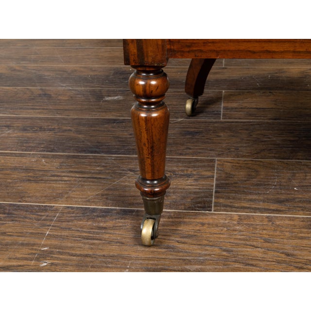 An English Regency period mahogany horseshoe back armchair from the 19th century, with balusters, large scrolling arms,...