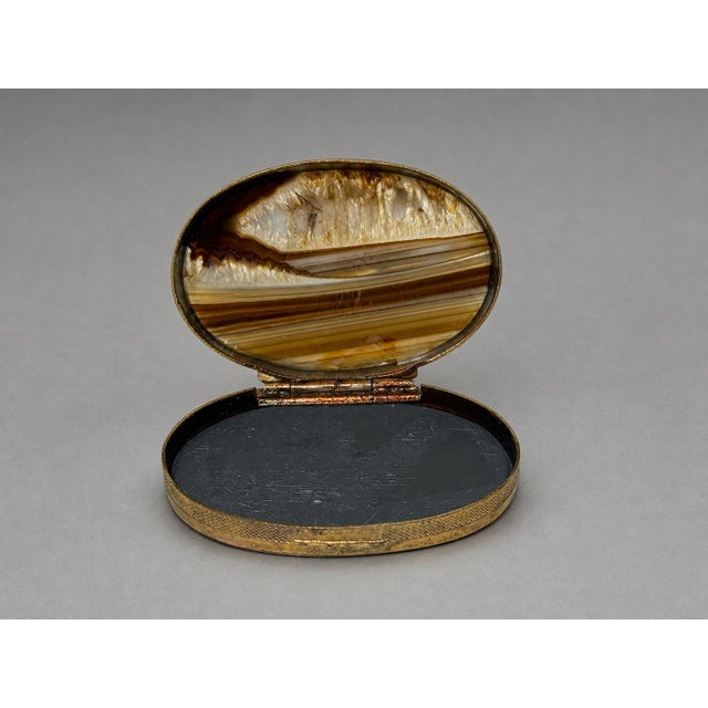 A fine antique Scottish oval snuff or trinket box, formed with a gilt brass mount and inset polished hardstone panels. The...