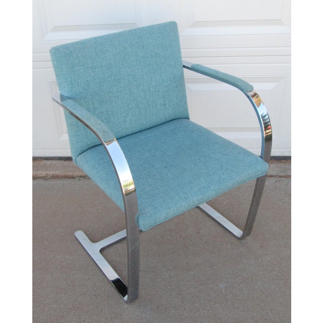 Brno style chair (designed by Ludwig Mies van der Rohe) with flat metal arm and fabric. The chair is not marked and from...