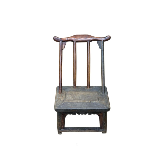 This diminutive, antique wooden chair captures a weathered, rustic charm through its distinct yoke-back design and low-...