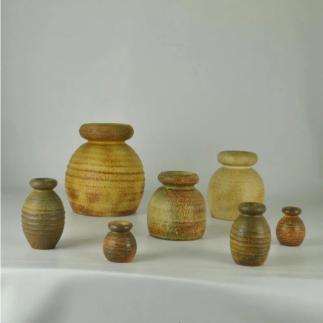 Set of seven Studio Pottery turned bulbous vases with rolled tire-shape necks Mid-Century Modern, glazed in ocher and...