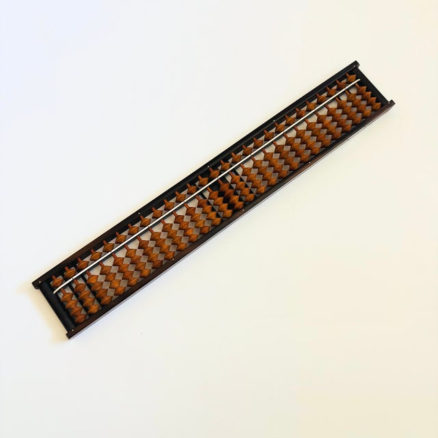 A beautiful vintage Japanese wood abacus. The frame is made of wood and the beads are made of a wood like resin material....