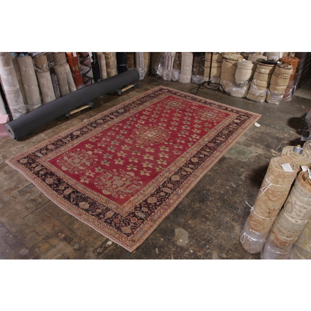 Hand knotted in wool originating from Turkey circa 1900-1910, this antique floral Gordes rug enjoys the marriage of an...