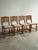 Antique English dining chairs crafted in solid oak with arched pegged backs, carved splats, and turned legs. Warm, time-...
