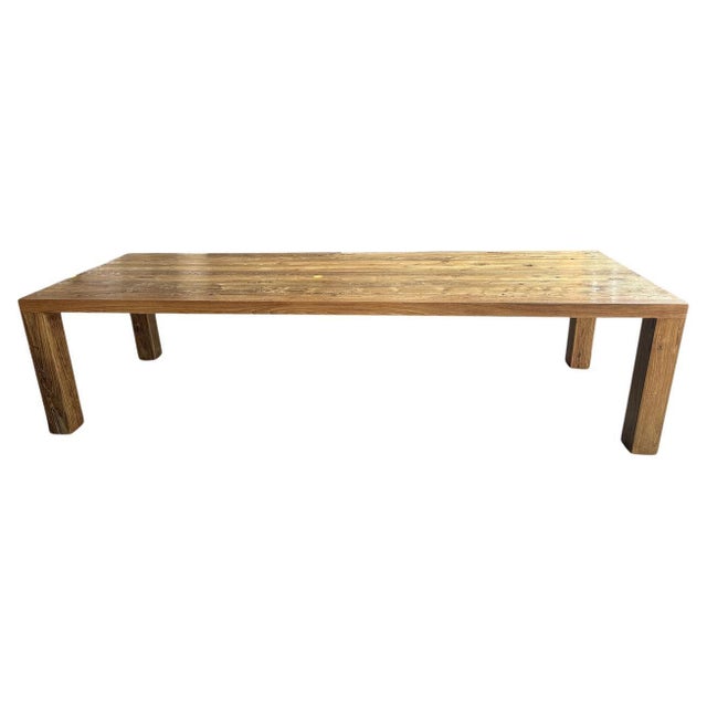 Impressive solid reclaimed teak wood dining table with 5” x 5” modern square legs and a 2.5” top. Finished with a natural...