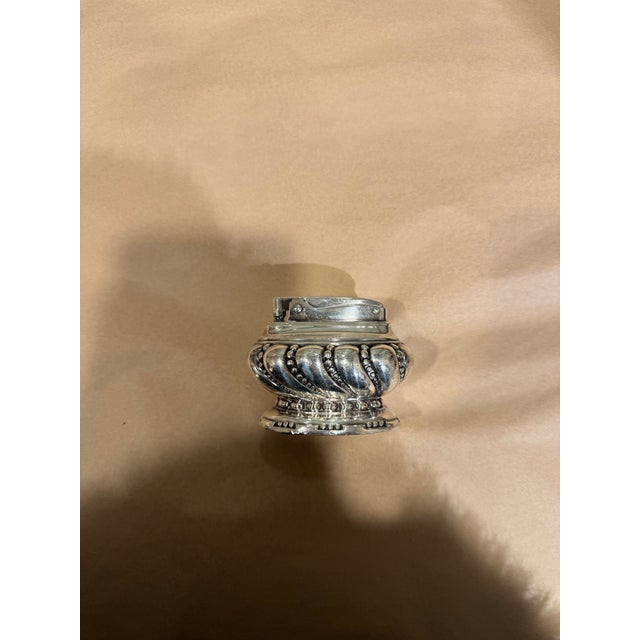 This is a vintage lighter. The maker is Ronson Crown. It is made of silver plate. The details are really attractive. A...