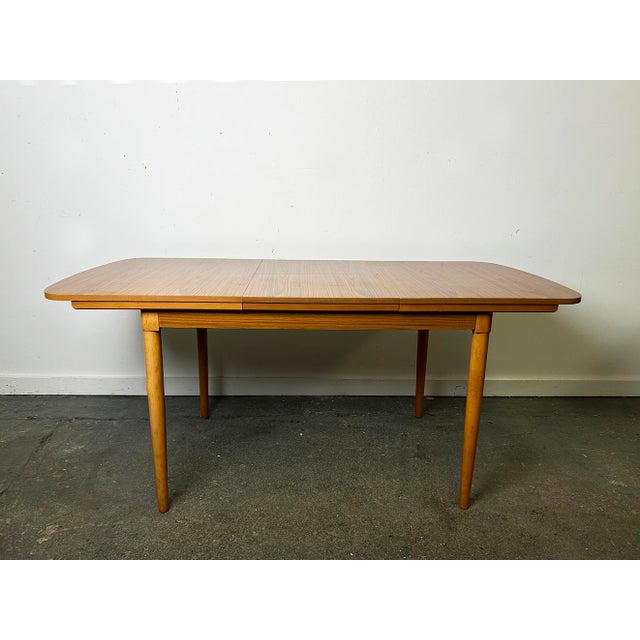 A Schreiber Mid-Century extending dining set, comprising a teak effect Formica dining table and four matching dining...