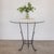 Beautiful wrought iron and glass center table from Spain, 1920s. Sculptural iron base with 3 curved legs and scroll...