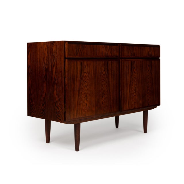 This stunning Danish Mid-Century Gunni Onmann credenza showcases the unparalleled beauty of richly grained rosewood,...
