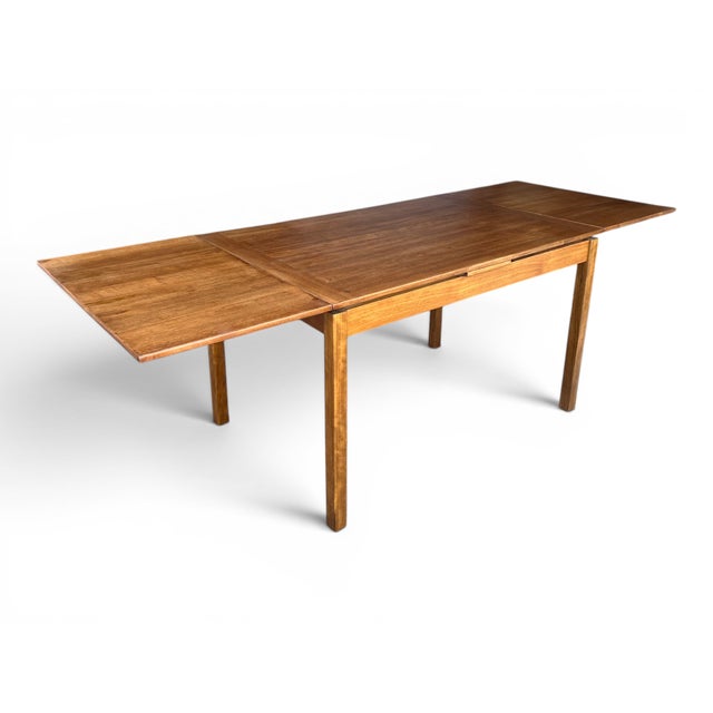 Richly figured teak, ingenious Danish craftsmanship, and effortless versatility make this Mid-Century Modern dining table...