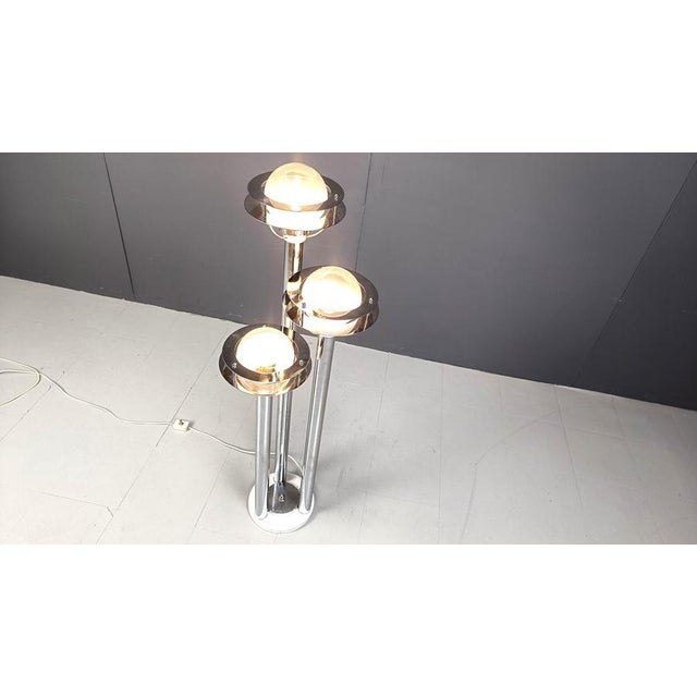 Striking vintage space age design floor lamp with three saturn like lamp shades. The lamp shades ar emade of chromed rings...