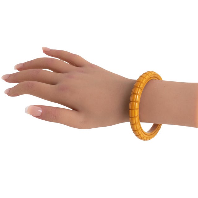 This amazing butterscotch Bakelite carved bracelet bangle features a spacer-domed shape with deep, geometric carvings all...