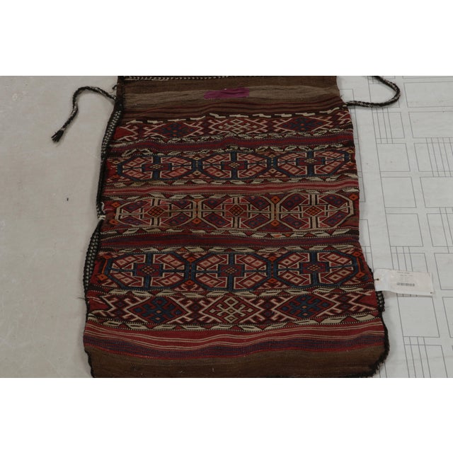 Handwoven in wool, this 2x4 flatweave textile is a collectible antique tribal bag, believed to originate from Turkey circa...