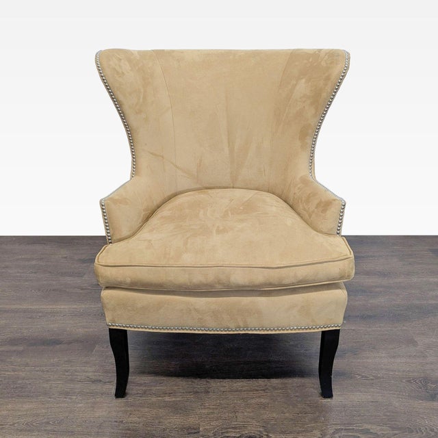 This Williams Sonoma Home lounge chair features a soft tan upholstery and elegant silver nailhead trim. The high back and...