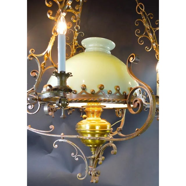 Very decorative wrought steel and brass frame hanging oil lamp chandelier, has been electrified for contemporary use. The...