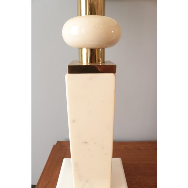 A Modernist marble table lamp. White and ivory colored marble with patinated brass details.