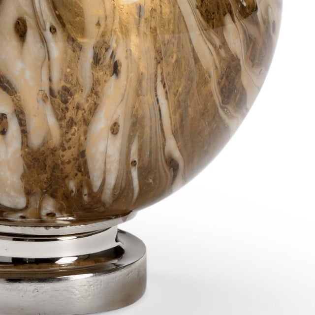 Be mesmerized by the swirls of the calacatta gold... Sitting atop an aluminum base with a polished nickel finish, cream,...