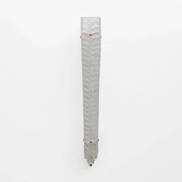 A pair of graniglia murano glass wall lamps, textured with a leaf-veined design, in crystal color. Elongated in shape,...