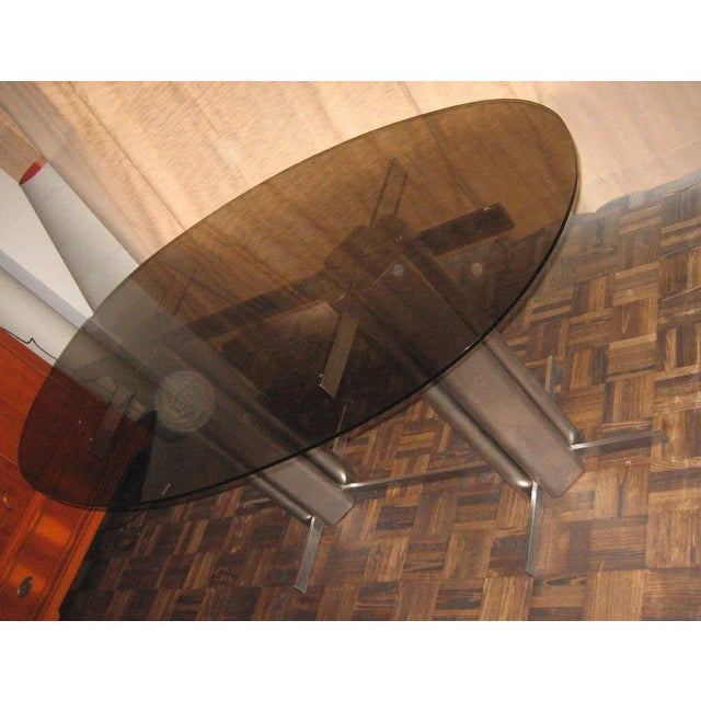 This oval dining table with a top made from St Gobain glass was produced in France.