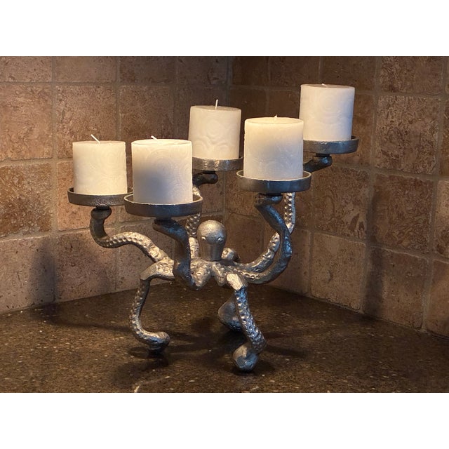 The candelabra features a detailed nautical octopus sculpture where the rising and swirling tentacles form platforms...
