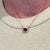 This beautiful pendant necklace features a 1.6 carat emerald cut ruby gemstone with a halo of natural earth mined...