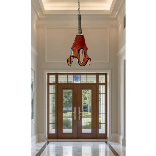This 14‑inch tall by 10‑inch wide pendant light has a sculptural presence shaped entirely by the dialogue between its...