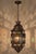 A striking vintage Moroccan hanging lantern, handcrafted in Marrakech from pierced metal with a rich dark bronze patina...